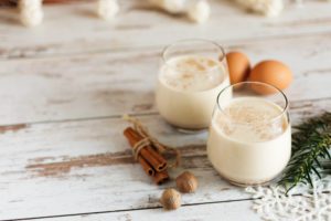 Glasses of lactose free eggnog with cinnamon and eggs
