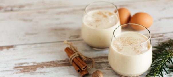 Glasses of lactose free eggnog with cinnamon and eggs