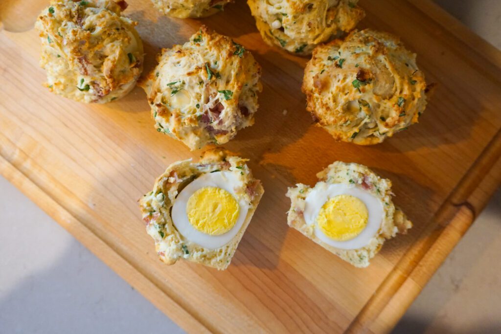 hard boiled egg inside muffin cut open on wooden cutting board