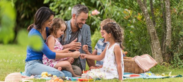 family enjoying afternoon picnic outside in the spring