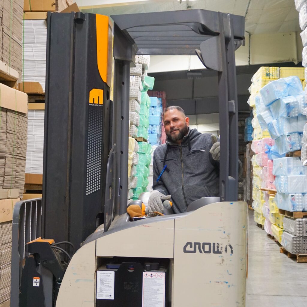 man sitting in forklift in warehouse