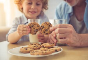 dad and son enjoying chocolate chip cookies and white milk