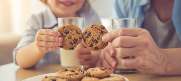 dad and son enjoying chocolate chip cookies and white milk