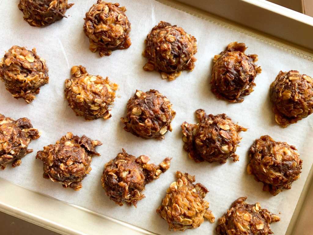 chocolate peanut butter oatmeal ball bites on parchment lined baking sheet