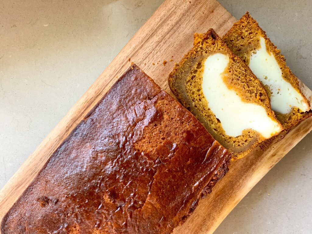 pumpkin cream cheese bread loaf sliced on wooden cutting board