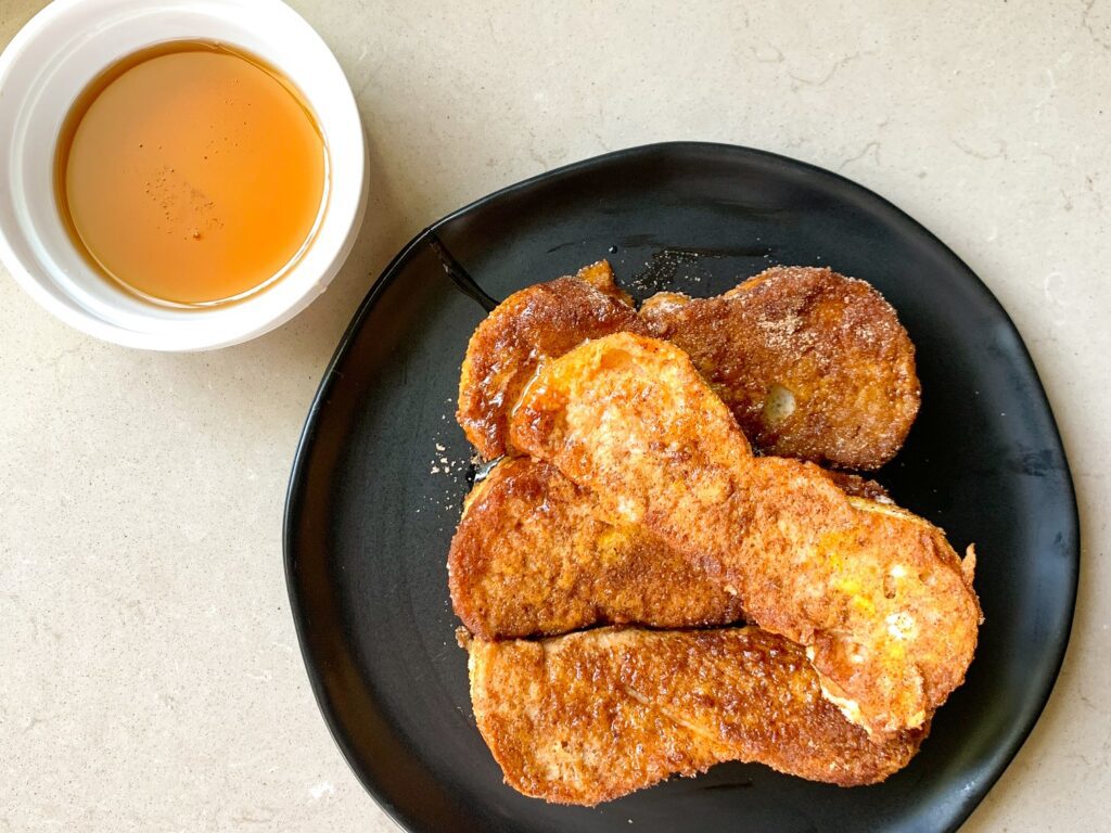 pumpkin french toast sticks plated with maple syrup dipping cup